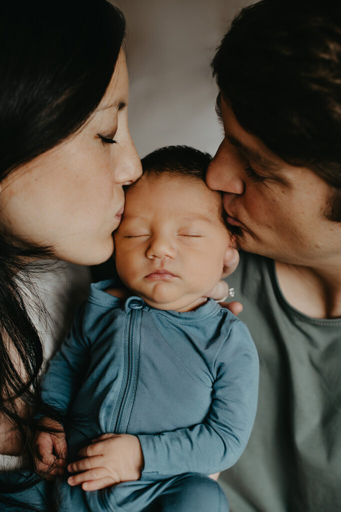 mom and dad kissing newborn Virginia Beach photographer